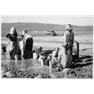 Femmes algériennes se ravitaillant en eau auprès de pompes. [légende d'origine]<br>