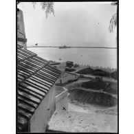 Le St-Augustin canonné le 4 août à 4h20 par le Breslau qui semblait exactement derrière la jetée dans le même sens que le Saint-Augustin. Vue prise de la montée de l'hôpital. Le Breslau était à l'endroit indiqué par une croix. L'angle de la maison en terrasse a reçu aussi un obus qui avait fait une large brèche environ à 20 centimètres de l'endroit marqué d'une croix. En s'y trouvant, on voyait la brèche où l'obus était allé éclater dans l'angle de la chambre. [légende d'origine]