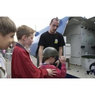 Un gendarme de l'escadron 14/1 équipe un enfant lors de la démonstration de la gendarmerie de Satory.