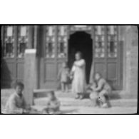 [Pékin. Une famille devant une maison].