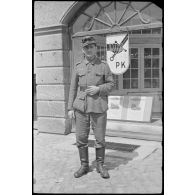 Hindenburgstrasse à Eydtkau (Eydtkuhnen) en Prusse-Orientale (Ostpreußen), un reporter de la Pk.697 devant les bureaux du journal de propagande intitulé Panzerfaust.