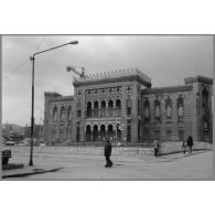 La bibliothèque de Sarajevo, incendiée le 25 août 1992 (elle comptait alors un million de volumes). Ici en reconstruction. [légende d'origine]