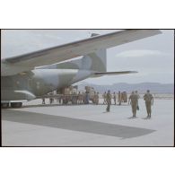 Les hommes du DMAT déchargent les colis de vivres fraîches du C160 sur la tarmac de l'aéroport d'Atar. [légende d'origine]<br>