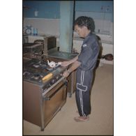 Serveur mauritanien dans la cuisine de la popote du DMAT d'Atar. [légende d'origine]<br>