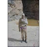 Formation des aides moniteurs commando et des élèves officiers de l'école militaire interarmes d'Atar à l'escalade et au rappel, aux techniques de cordes et d'assurance, au franchissement de fortune, au brancardage dans les falaises de l'Oued Illïj, région d'Atar et d'Azougui. Température d'exercice avoisisant les 40° en raison du rayonnement sur les parois rocheuses, 300 élèves et 10 aides moniteurs ont été formés pendant cette période. [légende d'origine]<br>
