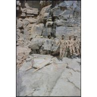 Formation des aides moniteurs commando et des élèves officiers de l'école militaire interarmes d'Atar à l'escalade et au rappel, aux techniques de cordes et d'assurance, au franchissement de fortune, au brancardage dans les falaises de l'Oued Illïj, région d'Atar et d'Azougui. Température d'exercice avoisisant les 40° en raison du rayonnement sur les parois rocheuses, 300 élèves et 10 aides moniteurs ont été formés pendant cette période. [légende d'origine]<br>