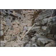 Formation des aides moniteurs commando et des élèves officiers de l'école militaire interarmes d'Atar à l'escalade et au rappel, aux techniques de cordes et d'assurance, au franchissement de fortune, au brancardage dans les falaises de l'Oued Illïj, région d'Atar et d'Azougui. Température d'exercice avoisisant les 40° en raison du rayonnement sur les parois rocheuses, 300 élèves et 10 aides moniteurs ont été formés pendant cette période. [légende d'origine]<br>