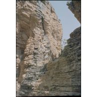 Formation des aides moniteurs commando et des élèves officiers de l'école militaire interarmes d'Atar à l'escalade et au rappel, aux techniques de cordes et d'assurance, au franchissement de fortune, au brancardage dans les falaises de l'Oued Illïj, région d'Atar et d'Azougui. Température d'exercice avoisisant les 40° en raison du rayonnement sur les parois rocheuses, 300 élèves et 10 aides moniteurs ont été formés pendant cette période. [légende d'origine]<br>