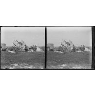 [Capotage d'un avion orné d’une croix de Lorraine. Un camion avec remorque emporte les débris].
