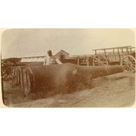 [Un artilleur pose devant deux tubes à mortier].