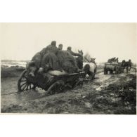 [Un convoi hippomobile sur une route détrempée].