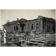 [Des tombes de fantassins allemands creusées devant une isba certainement transformée en hôpital de campagne].