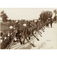 [Fusils en faisceaux en bordure de route].