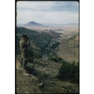 [Un soldat du 12e RD en observation aux jumelles du haut d'un djebel].