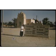 [Soldat de la 2e Compagnie Automobile Saharienne de Transport (CAST) devant une borne kilométrique à l'entrée de Ouargla].