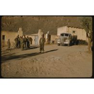 [Un groupe de soldats de la 2e Compagnie Automobile Saharienne de Transport (CAST) à l'entrée d'un village saharien].