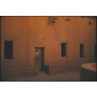 [Entrée d'un bâtiment dont la porte est surmontée d'une croix].