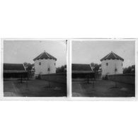 [Vue prise à l'intérieur d'un poste avec tour d'observation. Au pied de celle-ci, des militaires portant le casque colonial].<br>