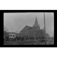 [Colonne de chevaux devant une église].