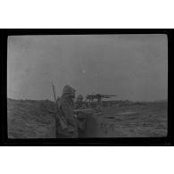 [Militaires postés derrière une mitrailleuse dans une tranchée].