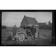 [Militaires posant devant une voiture].
