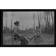 [Militaire photographiant une femme assise].