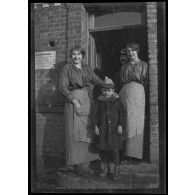 [Deux femmes et un enfant sur un perron].