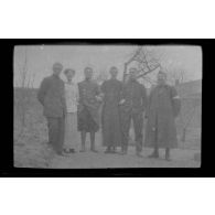 [Photographie de groupe : un couple, des militaires dont infirmiers et médecins, un prêtre].