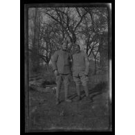 [Portrait de deux militaires en pied, chacun portant un brassard].