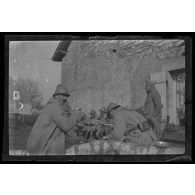 [Repas de militaires assis contre un mur].