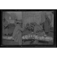 [Repas de militaires assis contre un mur].