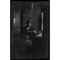 [Portrait de femme lisant une lettre dans un intérieur].
