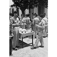 Cour du quartier de l'EM de la 21e DI à Batna : préparation d'un méchoui à l'occasion de la Saint-Gabriel. [légende d'origine]