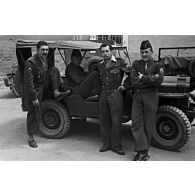 Bras croisés, SGT Gence devant jeep. [légende d'origine]