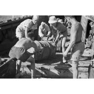 Dans le port de Marsa Matruh, le déchargement du ravitaillement de l'Axe par des prisonniers anglais et néo-zélandais.
