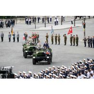 Sur la place de la Concorde, à bord d'un command-car, Emmanuel Macron, président de la République et le général d'armée François Lecointre, chef d'état-major des Armées (CEMA), passent les troupes en revue lors de la cérémonie du 14 juillet 2020.