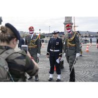 Pendant les derniers préparatifs, une militaire photographie deux militaires autrichiens avec un second-maître féminin avant la cérémonie du 14 juillet sur la place de la Concorde.