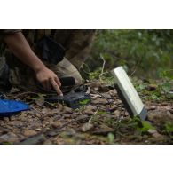 Un marsouin du 9e régiment d'infanterie de marine (9e RIMa) utilise un téléphone satellite pour contacter son commandement lors d'une patrouille à Maripasoula, en Guyane française.