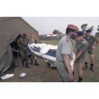 Lors de l'arrivée de blessés provenant de Kibeho au campement de l'élément militaire médical d'intervention rapide (EMMIR) à Cyangugu, des militaires rwandais aident au brancardage d'un patient.