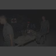 Brancardage de nuit d'un blessé par un capitaine du SIRPA et un personnel médical au campement de l'élément militaire médical d'intervention rapide (EMMIR) à Cyangugu, à proximité d'un VAB sanitaire.