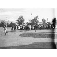 [Une foule d'hommes et de femmes malgaches marchent à travers le village de Betroka.]