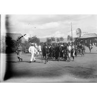 [Une foule d'hommes et de femmes malgaches marchent à travers le village de Betroka.]