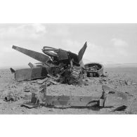 Un Leutnant et deux hommes examinent la carcasse déchiquetée d'un char Sherman M4 .