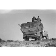 Deux soldats manoeuvrent un treuil installé sur un camion Dodge T215 d'origine américaine.