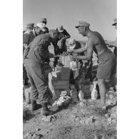 Des soldats ont la joie de recevoir du ravitaillement d'origine italienne (chocolat, vin, savon).