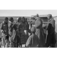 Une voiture Kfz-1 (Einheits-Personenkraftwagen Kfz.1) d'un convoi de ravitaillement en eau (Wasser-Kolonne 651) est entourée de civils libyens.