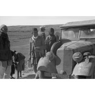 Une voiture Kfz-1 (Einheits-Personenkraftwagen Kfz.1) d'un convoi de ravitaillement en eau (Wasser-Kolonne 651) est entourée de civils libyens.