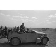 A bord d'une voiture, le général italien et son état-major quittent le lieu de la réunion.