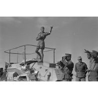 Le chef d'une unité de reconnaissance (Spähtruppführer), l'adjudant (Feldwebel) Apsel observe aux jumelles sur le toit d'un Sd.kfz.222 (immatriculé 642 265).