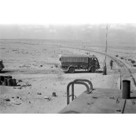 A bord d'une locomotive Henschel diesel, la voie ferrée croise une route.